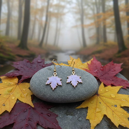 Maple leaf earrings on stone with forest background