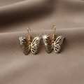 Schmetterlingsohrringe auf Taupe-Wildleder